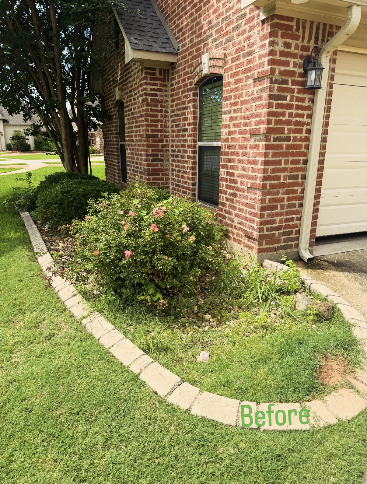 Corner bed makeover with decorative rock — before
